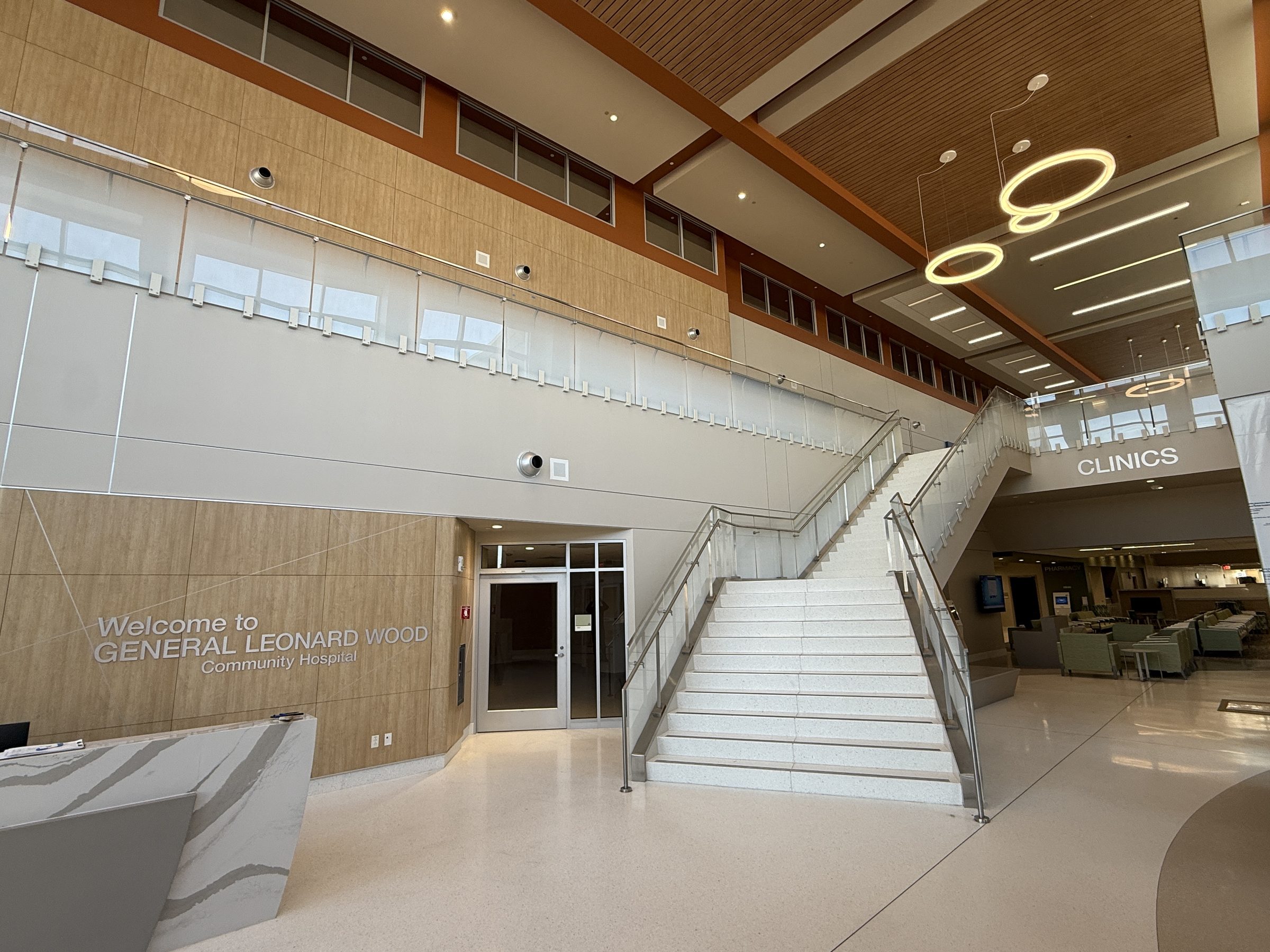 Glass guards on standoffs along a hospital lobby stair and balcony, Fort Leonard Wood