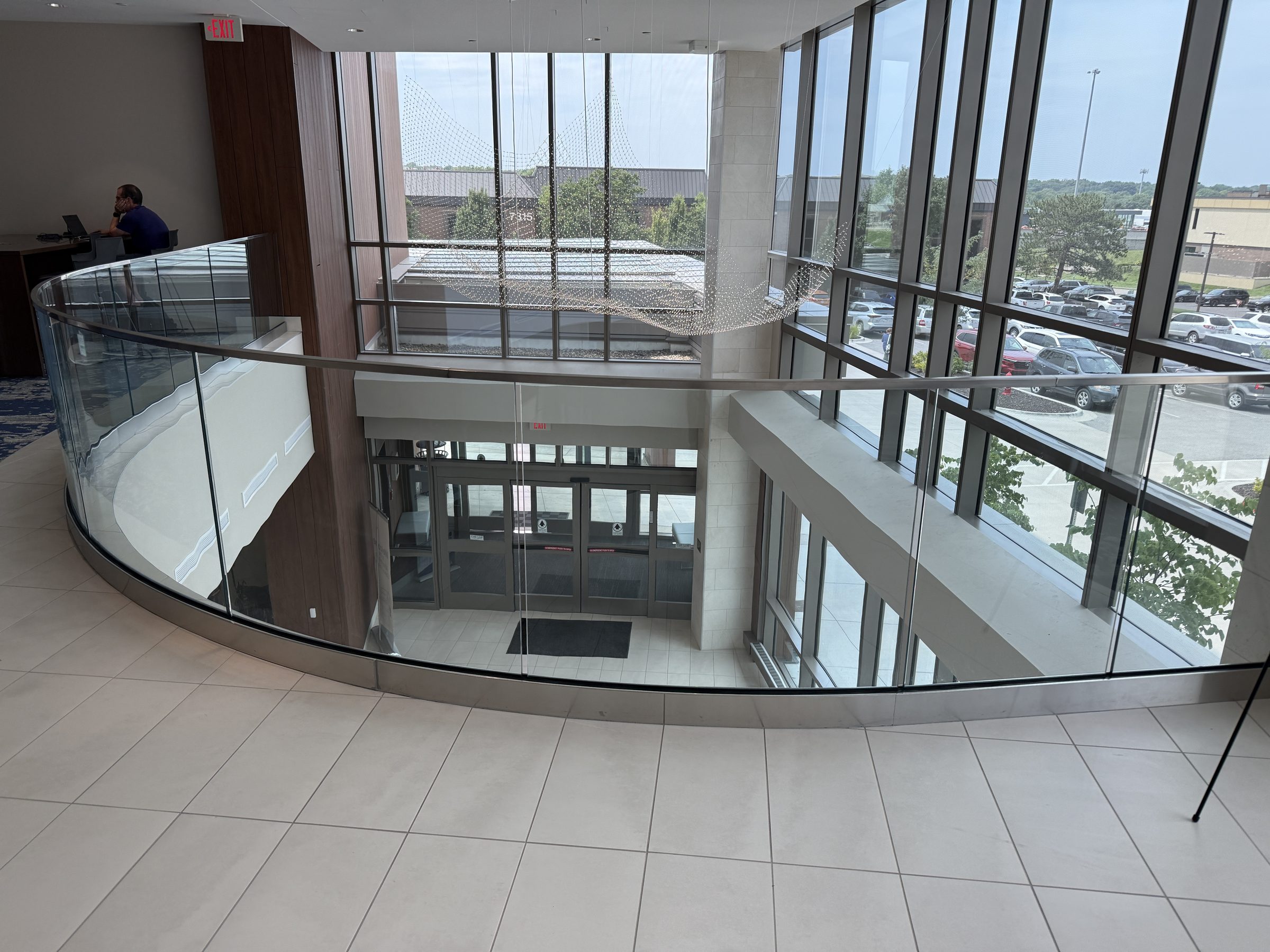 Curved glass guard in a base shoe around a two-storey atrium, Advent Health Cancer Center