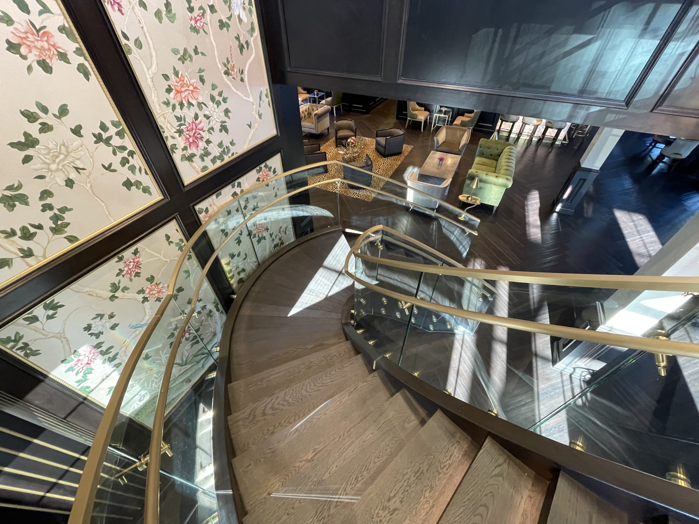 A curved stair with glass guards and a brass handrail, seen from above, Urbana Country Club