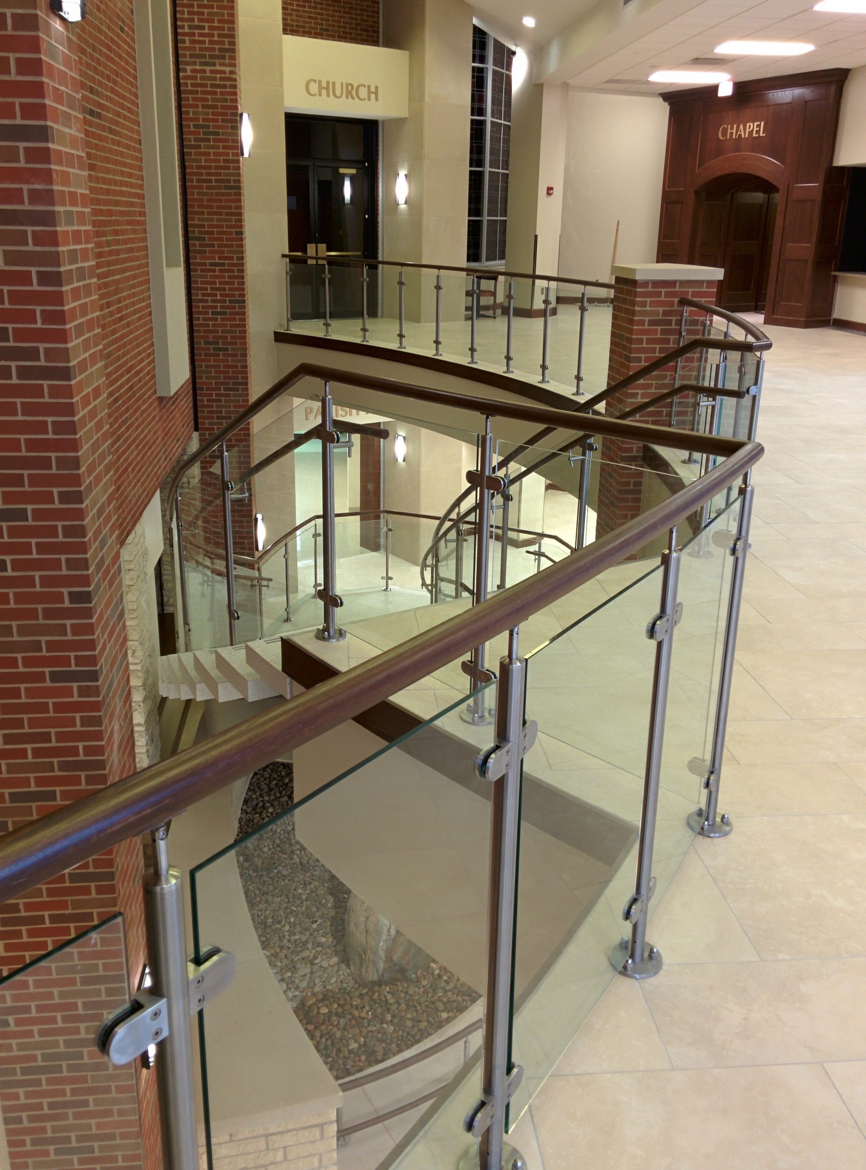 Glass panels in clips between stainless posts around a stair opening, St Ann’s, Prairie Village