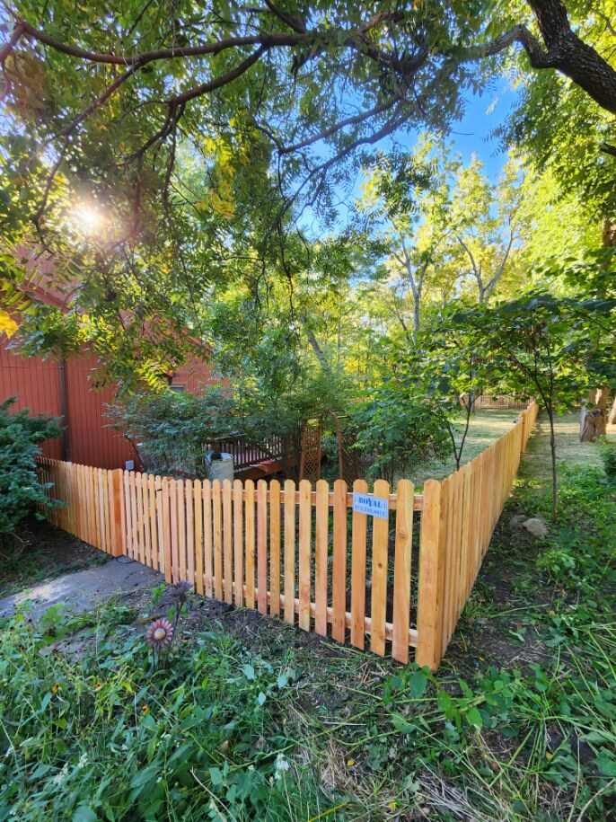 Spaced cedar picket fence around a garden bed