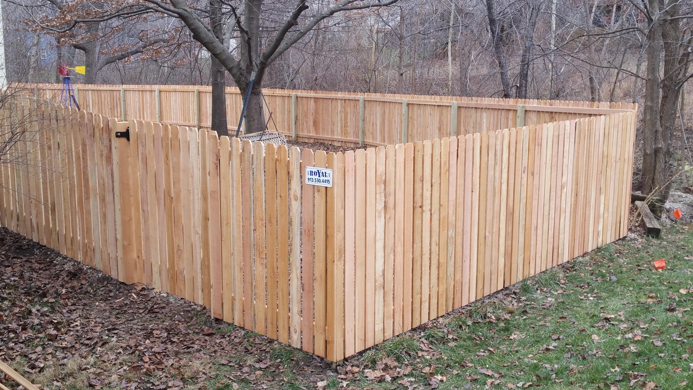 Five-foot cedar fence with narrow air spaces between pickets in a wooded backyard