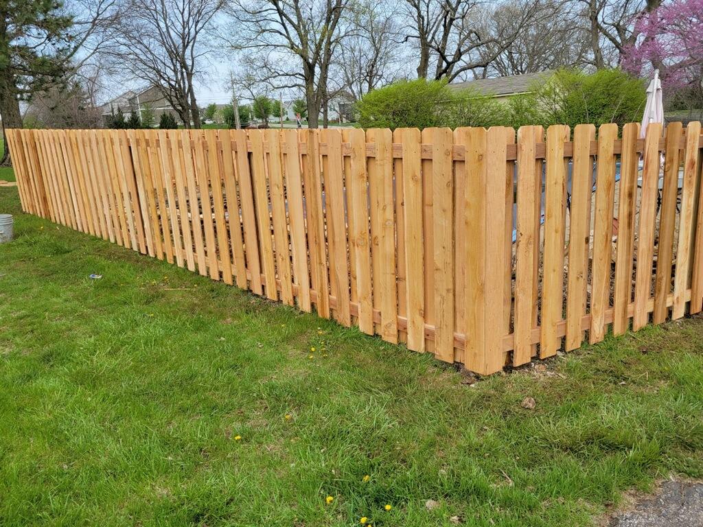 Five-foot cedar shadowbox fence across a green lawn