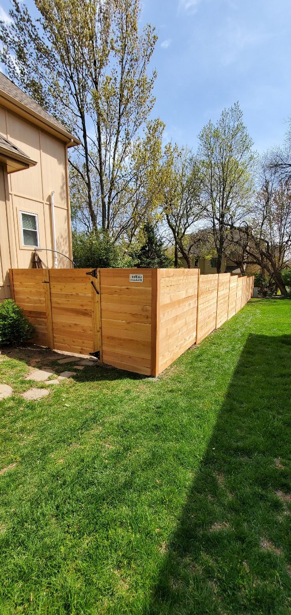 Cedar fence corner beside a backyard lawn