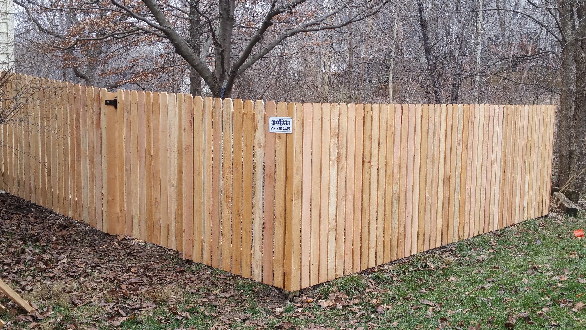Cedar privacy fence along a wooded backyard