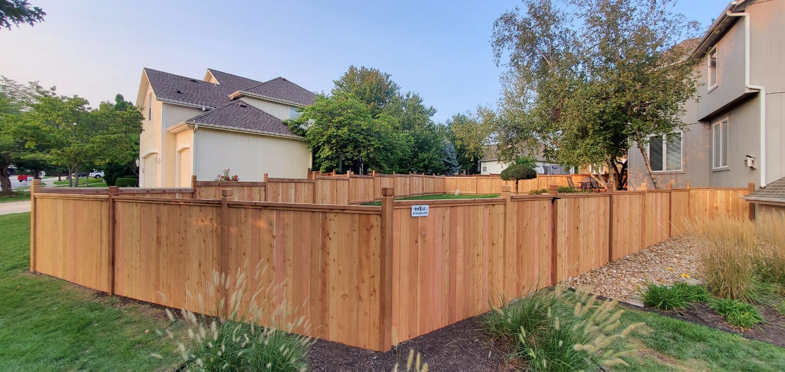 Cedar privacy fence with post caps wrapping a corner backyard