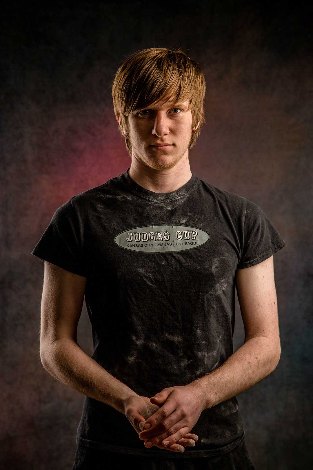 High school senior gymnast creating chalk dust during a creative studio portrait session at Gallery Portraiture in Kansas City.