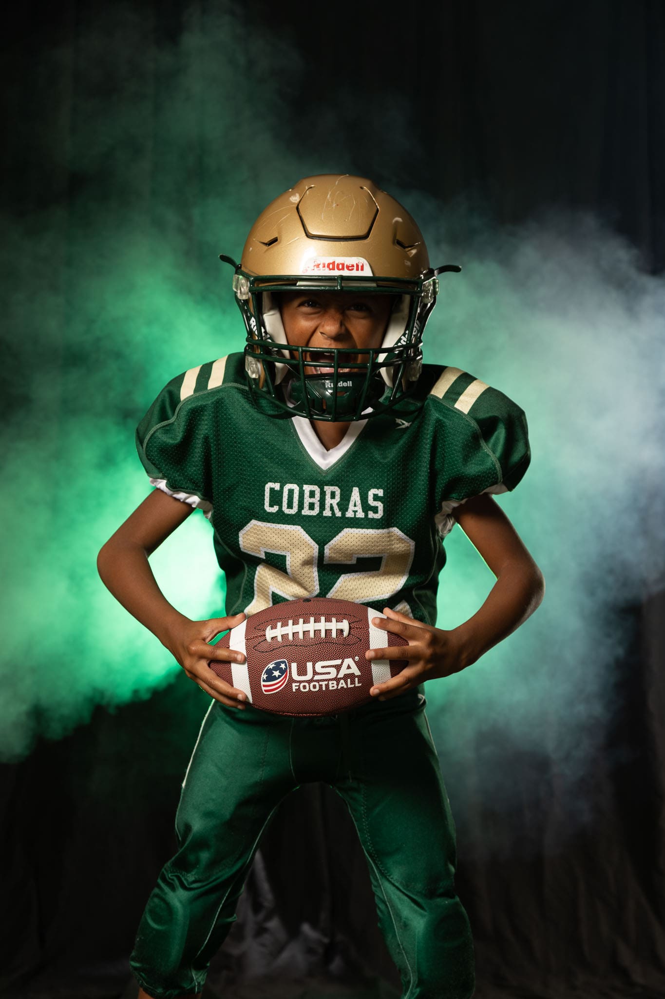 Football Media Day, dramatic sports portrait with athlete in studio using bold lighting and intense pose