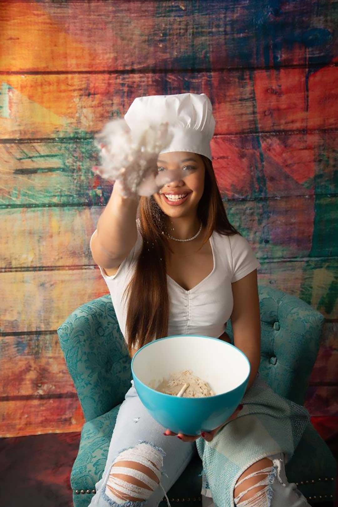 High school senior dressed as a chef tossing flour during a creative portrait session at Gallery Portraiture in Kansas City.